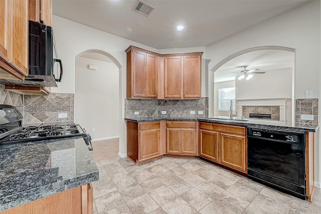 kitchen with tasteful backsplash, sink, dark stone countertops, ceiling fan, and black appliances