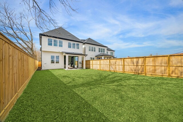 back of house with a patio area, a lawn, and a fenced backyard