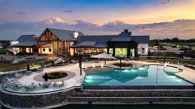 pool at dusk featuring a patio area