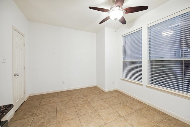 tiled spare room with ceiling fan