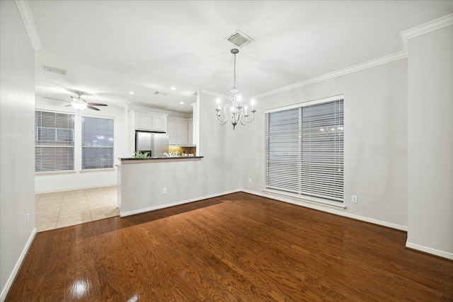 unfurnished dining area with crown molding, ceiling fan with notable chandelier, and light hardwood / wood-style flooring