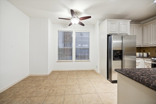 kitchen featuring backsplash, dark stone counters, light tile patterned floors, ceiling fan, and stainless steel fridge with ice dispenser