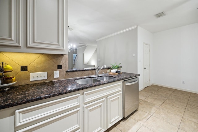 kitchen featuring sink, dishwasher, dark stone countertops, white cabinetry, and decorative backsplash