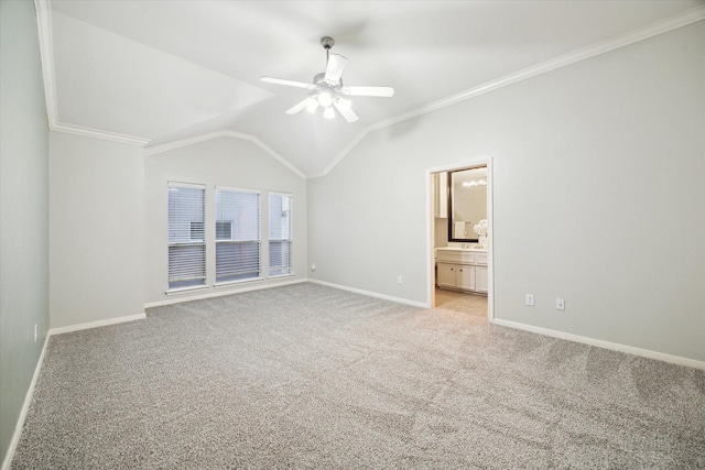 interior space with ensuite bath, ceiling fan, ornamental molding, light carpet, and vaulted ceiling