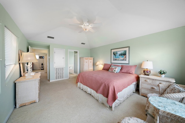 bedroom with ceiling fan, connected bathroom, vaulted ceiling, and light carpet