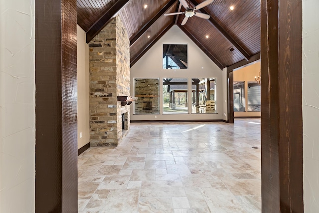 entryway featuring wood ceiling, a fireplace, beam ceiling, and high vaulted ceiling