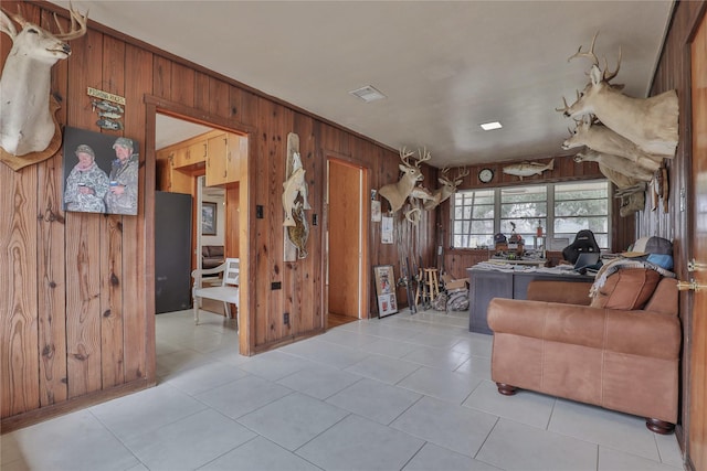 living room with light tile patterned flooring and wooden walls