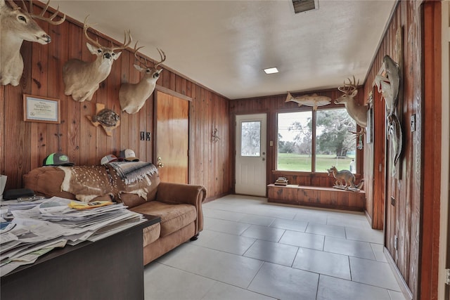 bedroom featuring light tile patterned flooring, access to exterior, and wood walls