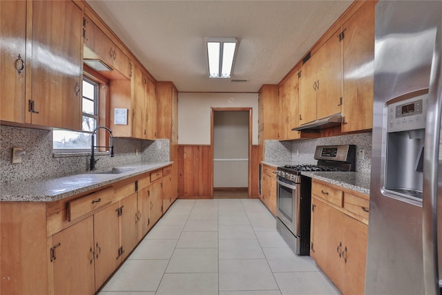 kitchen with appliances with stainless steel finishes, sink, decorative backsplash, and light tile patterned floors