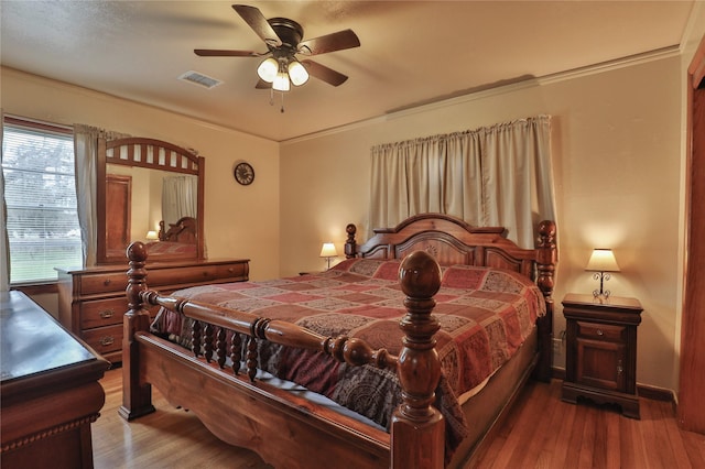 bedroom featuring hardwood / wood-style flooring, ceiling fan, and ornamental molding