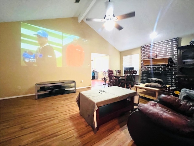 living room with high vaulted ceiling, wood-type flooring, ceiling fan, a brick fireplace, and beam ceiling