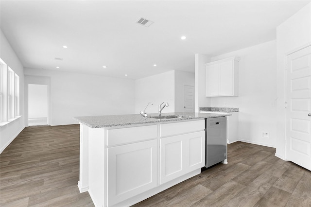 kitchen with white cabinetry, an island with sink, sink, stainless steel dishwasher, and light stone countertops