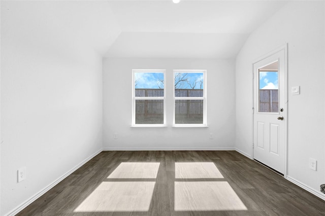 unfurnished room featuring lofted ceiling and dark hardwood / wood-style floors