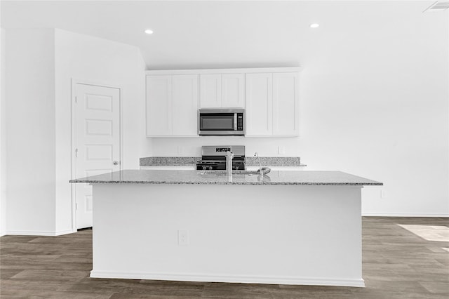 kitchen featuring dark hardwood / wood-style floors, white cabinetry, a kitchen island with sink, light stone counters, and stainless steel appliances