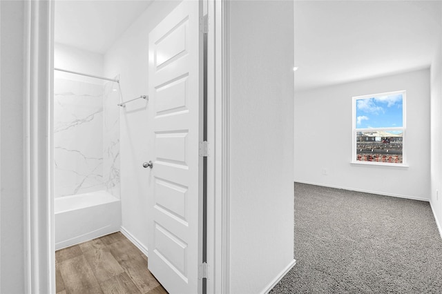 bathroom with hardwood / wood-style floors and tiled shower / bath combo