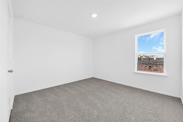 unfurnished room featuring dark carpet