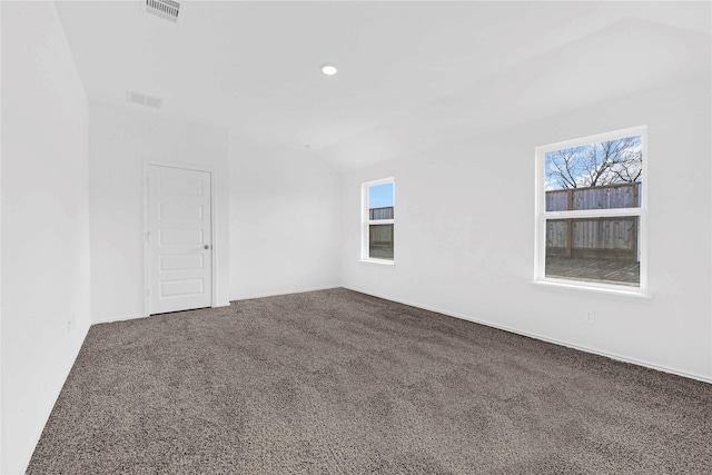 spare room featuring carpet floors, plenty of natural light, and vaulted ceiling