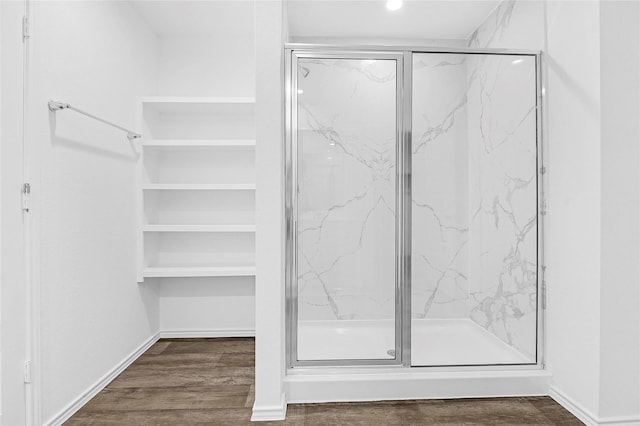 bathroom with hardwood / wood-style flooring and an enclosed shower