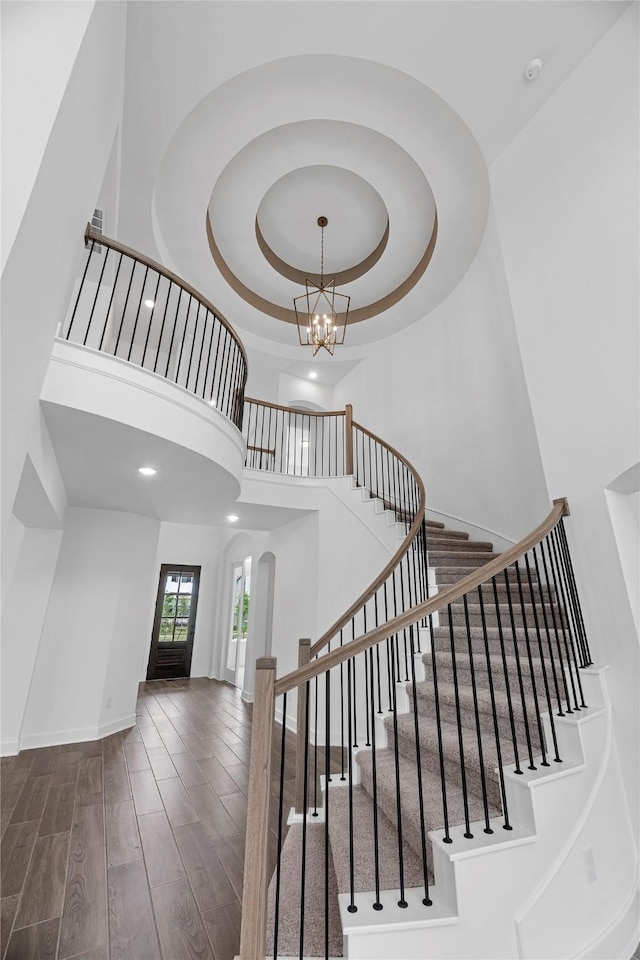 8318 Aussie Beadhead Dr, Fulshear, TX 77441 - stairs featuring a towering ceiling, wood finished floors, a chandelier, arched walkways, and recessed lighting