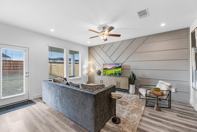 living room featuring ceiling fan, a healthy amount of sunlight, and light wood-type flooring