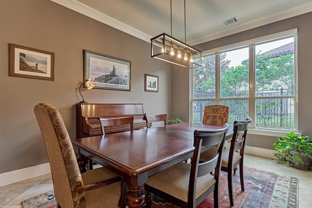 dining area with baseboards, light tile patterned floors, visible vents, and crown molding