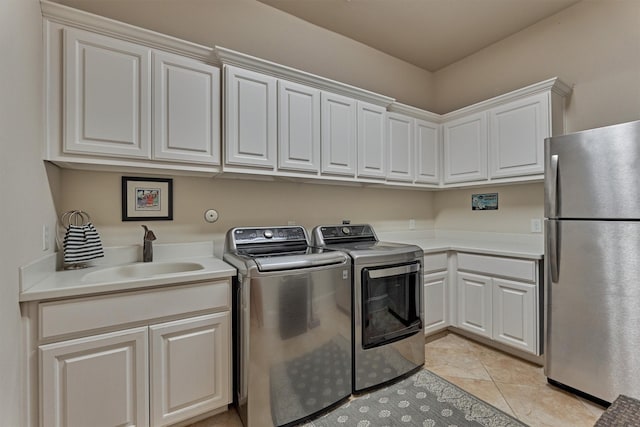 laundry room with cabinet space, a sink, washing machine and clothes dryer, and light tile patterned floors