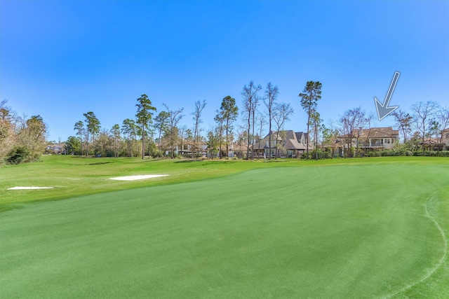 view of community with golf course view and a lawn