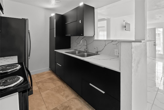 kitchen featuring sink, light tile patterned floors, stainless steel refrigerator, backsplash, and black electric range