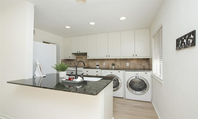 laundry room featuring light hardwood / wood-style floors, separate washer and dryer, and sink