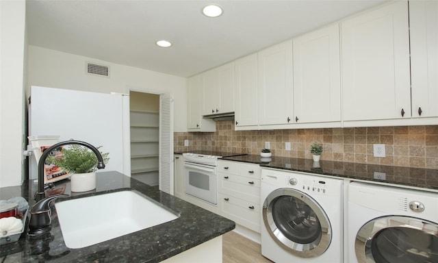 washroom with washer and dryer, sink, and light hardwood / wood-style floors