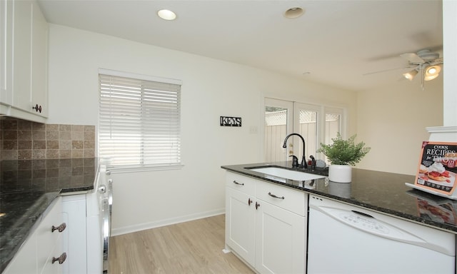 kitchen featuring sink, tasteful backsplash, dark stone countertops, dishwasher, and white cabinets