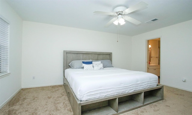 carpeted bedroom with ceiling fan and ensuite bath