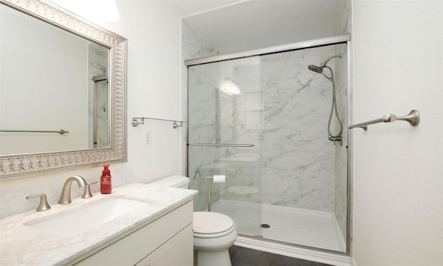 bathroom with walk in shower, vanity, and toilet