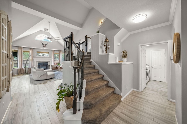 staircase featuring lofted ceiling, washer / clothes dryer, and ceiling fan