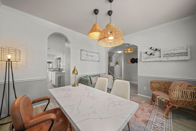 dining area with wood-type flooring and ornamental molding