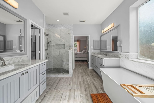 bathroom featuring hardwood / wood-style flooring, vanity, and separate shower and tub