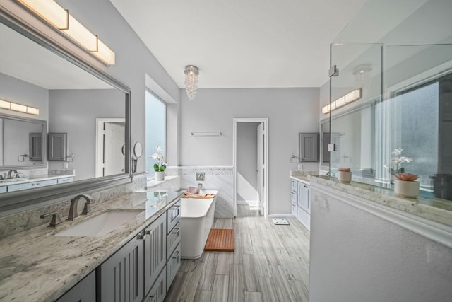 bathroom featuring plus walk in shower, wood-type flooring, tile walls, and vanity