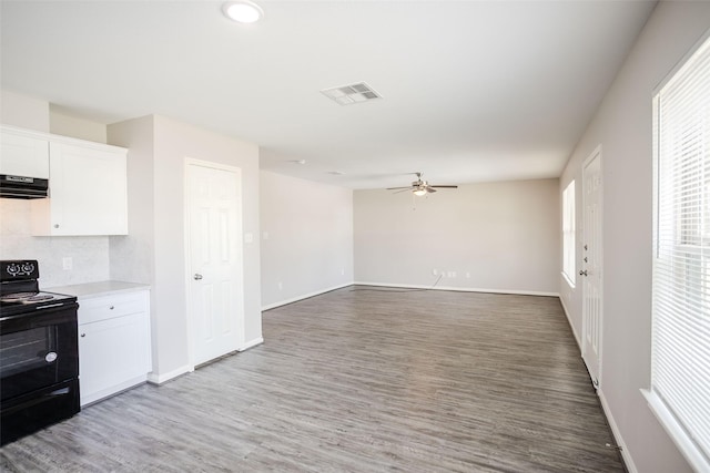 kitchen featuring white cabinetry, wood-type flooring, electric range, ceiling fan, and range hood