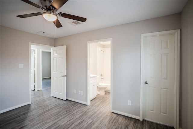 unfurnished bedroom featuring hardwood / wood-style floors, ensuite bath, and ceiling fan