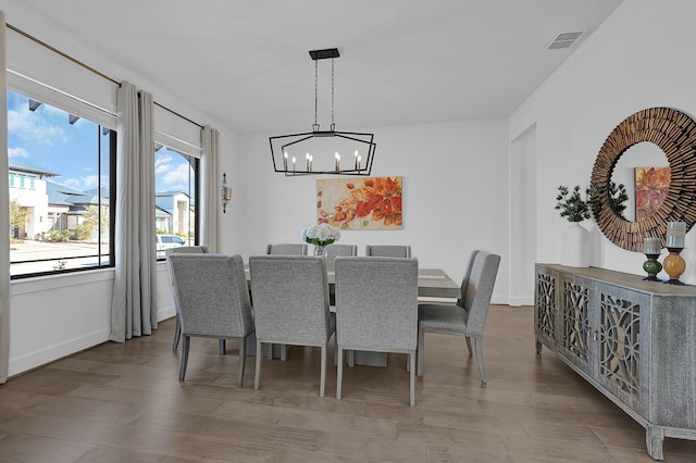 dining area featuring an inviting chandelier and hardwood / wood-style floors