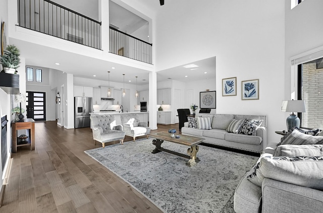 living room featuring hardwood / wood-style flooring, sink, and a high ceiling