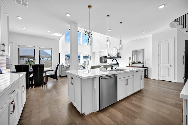 kitchen with sink, stainless steel dishwasher, pendant lighting, a kitchen island with sink, and white cabinets