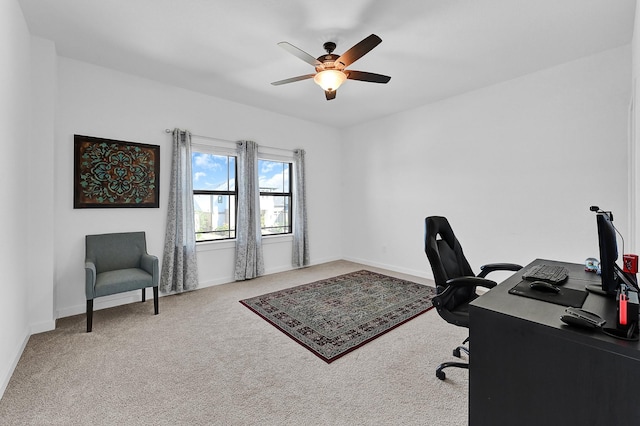 carpeted office space featuring ceiling fan