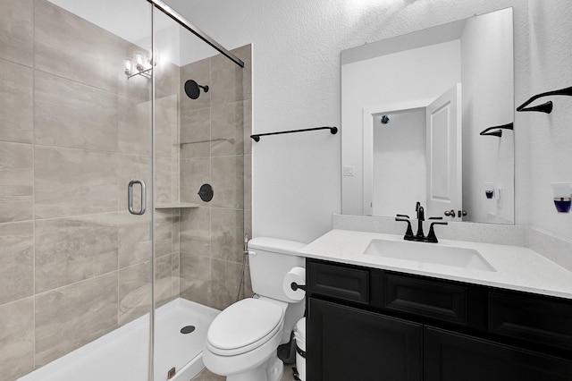 bathroom with vanity, toilet, and a shower with door