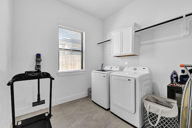 laundry area with washing machine and dryer and cabinets