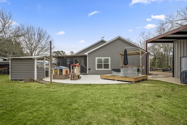 rear view of property with a storage shed, a patio area, a yard, a wooden deck, and a sunroom