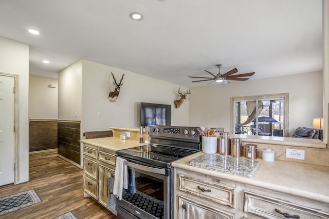 kitchen with dark hardwood / wood-style flooring, stainless steel electric stove, and ceiling fan