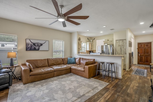 living room featuring hardwood / wood-style floors, a textured ceiling, and ceiling fan