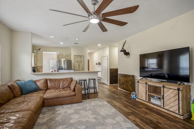 living room with ceiling fan and dark hardwood / wood-style floors