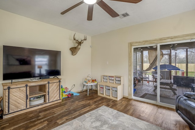 living room featuring ceiling fan and dark hardwood / wood-style flooring